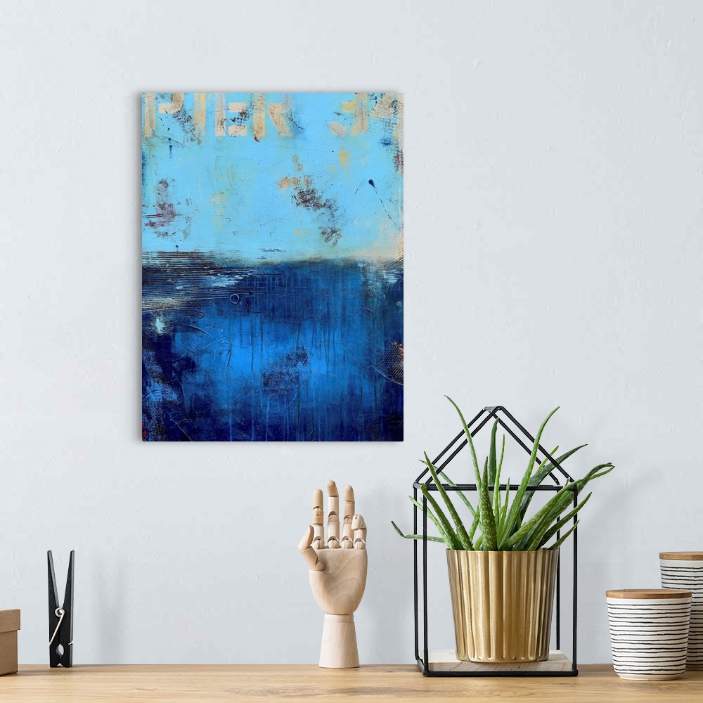 A bohemian room featuring A contemporary abstract painting using a light blue on the top portion of the image and a dark bl...