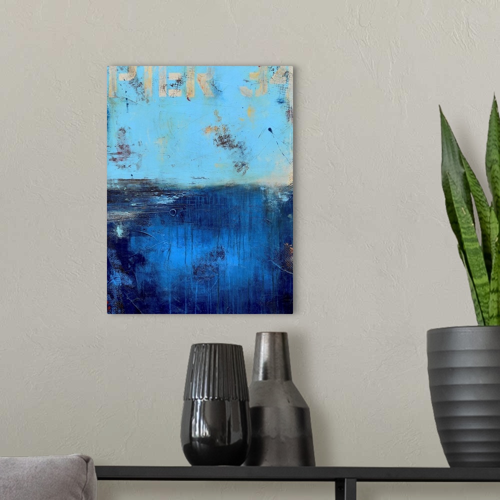 A modern room featuring A contemporary abstract painting using a light blue on the top portion of the image and a dark bl...