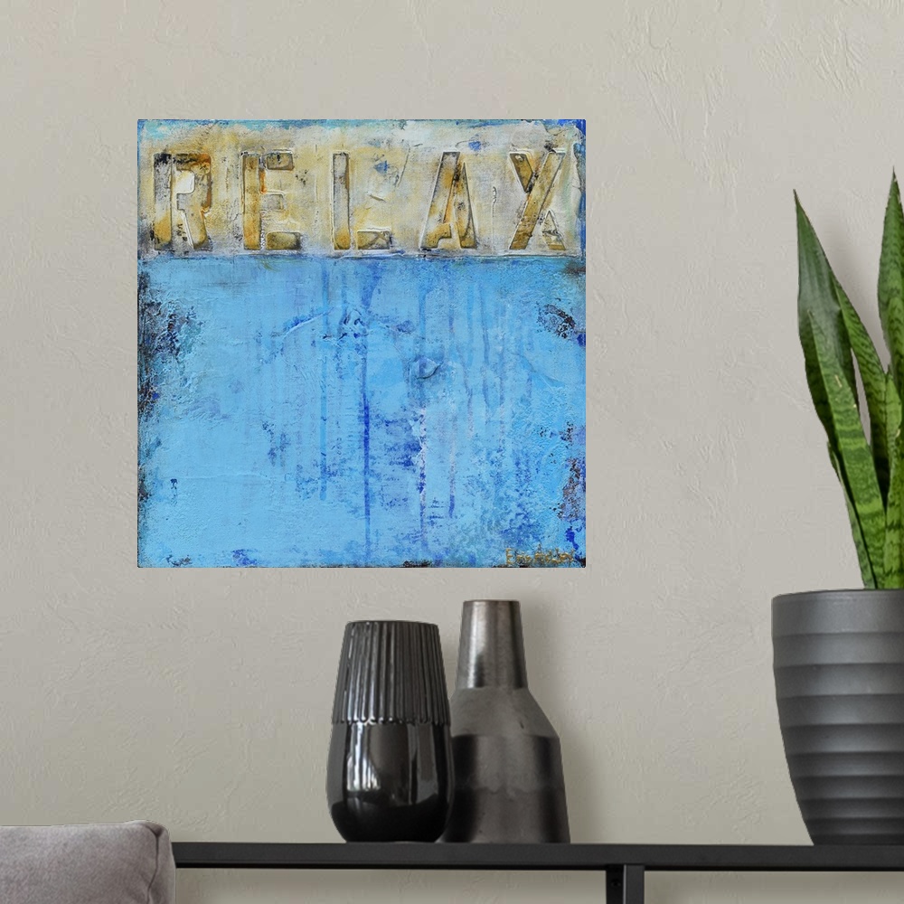 A modern room featuring "Relax" written in gray, gold, and white across the top of a square painting with a light blue ab...