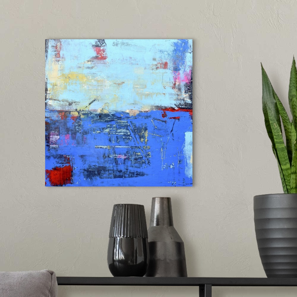 A modern room featuring A contemporary abstract painting using a dark and light blue meeting face to face.