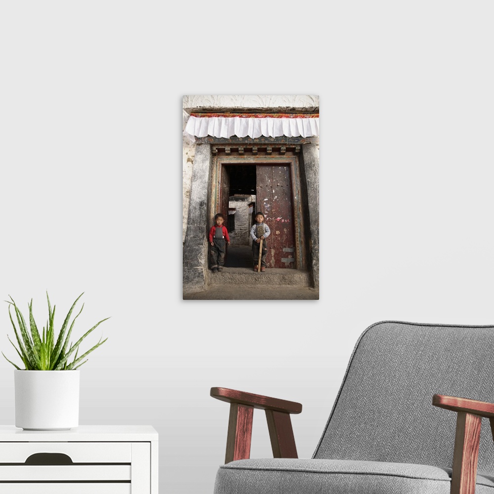 A modern room featuring China, Tibet, Lhasa, Tibetan boys guarding the doorway to their traditional home