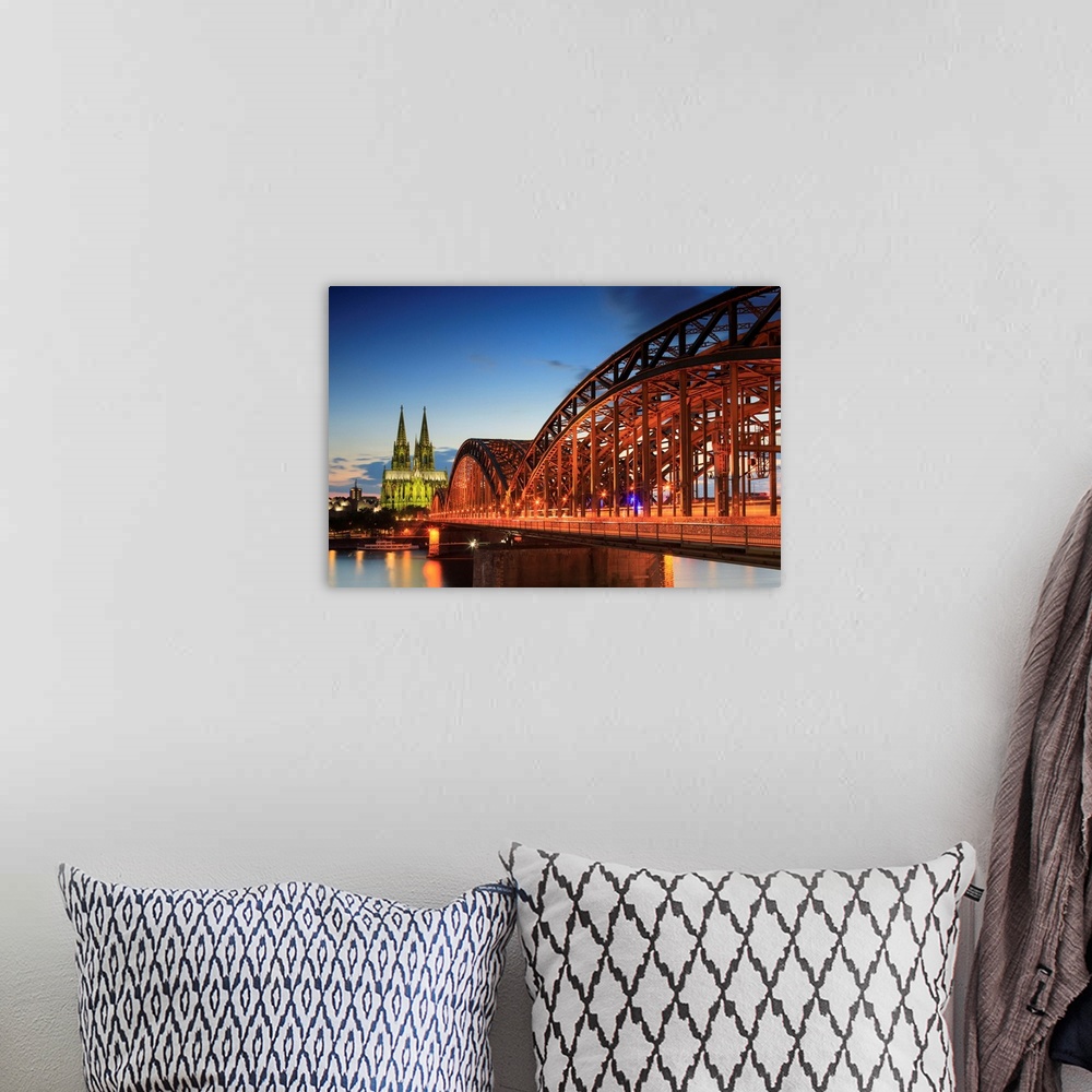 A bohemian room featuring Germany, North Rhine-Westphalia, Cologne, Cologne Cathedral and Hohenzollern Bridge in the evening.