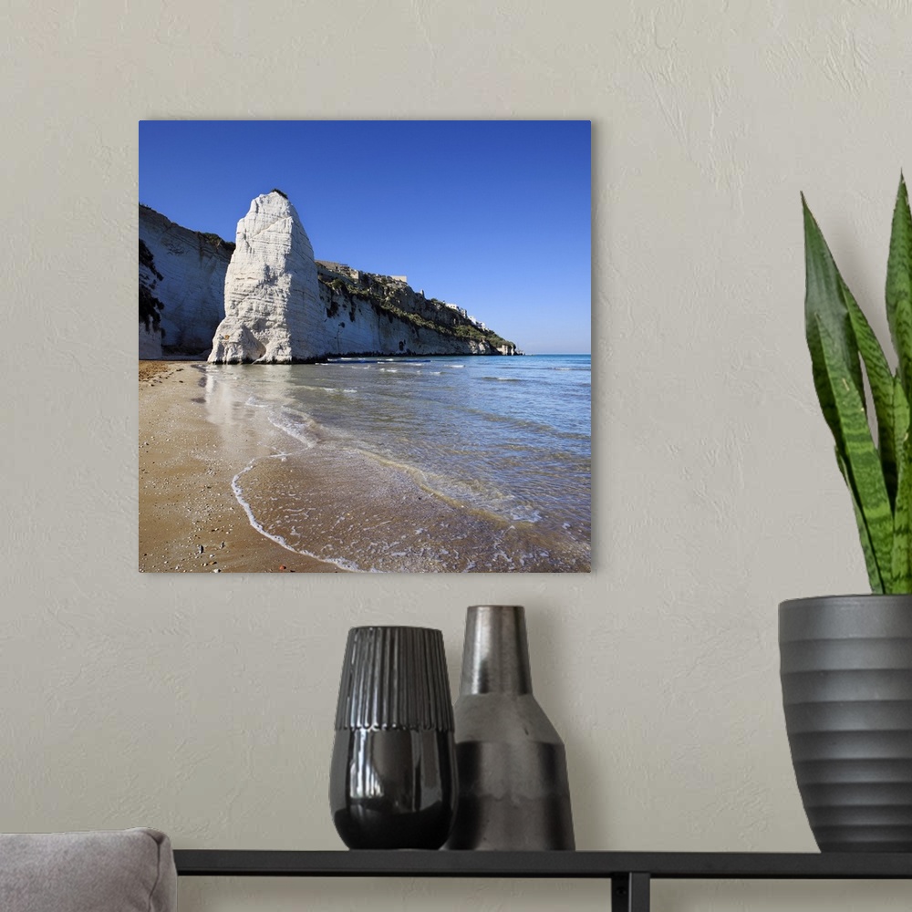 A modern room featuring Italy, Apulia, Gargano, Vieste, Pizzomunno rock and beach, with the town
