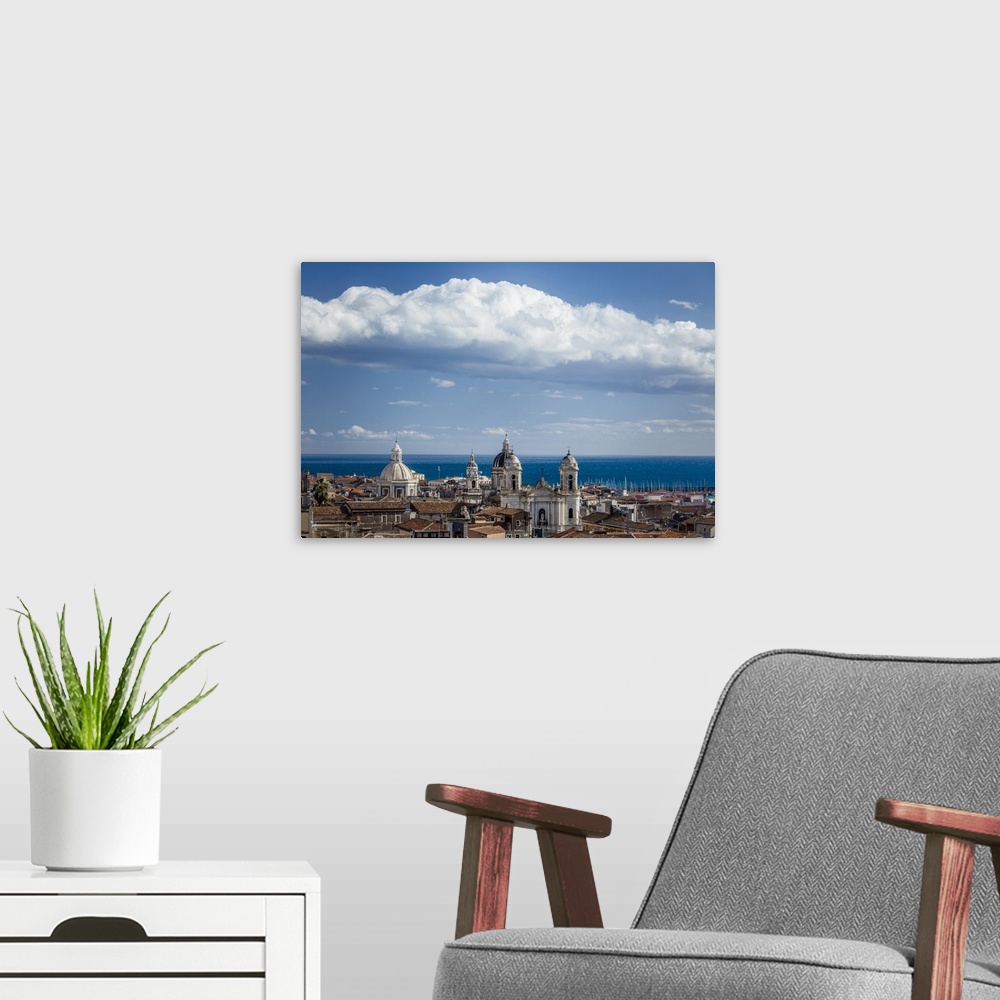 A modern room featuring Italy, Sicily, Mediterranean area, Catania district, Catania, View of the sea and baroque domes.