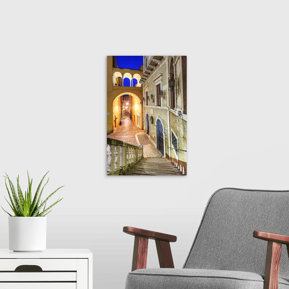 A modern room featuring Italy, Marches, Fermo district, Fermo, Piazza del Popolo (People's Square) at night.