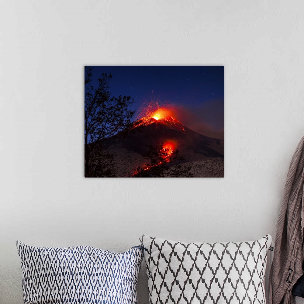 A bohemian room featuring Italy, Sicily, Catania district, Mount Etna, South-east crater eruption at night, lava flowing to...