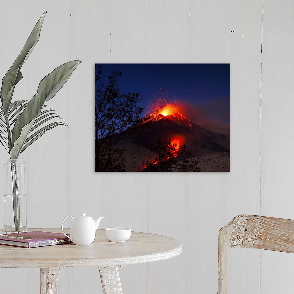 A farmhouse room featuring Italy, Sicily, Catania district, Mount Etna, South-east crater eruption at night, lava flowing to...