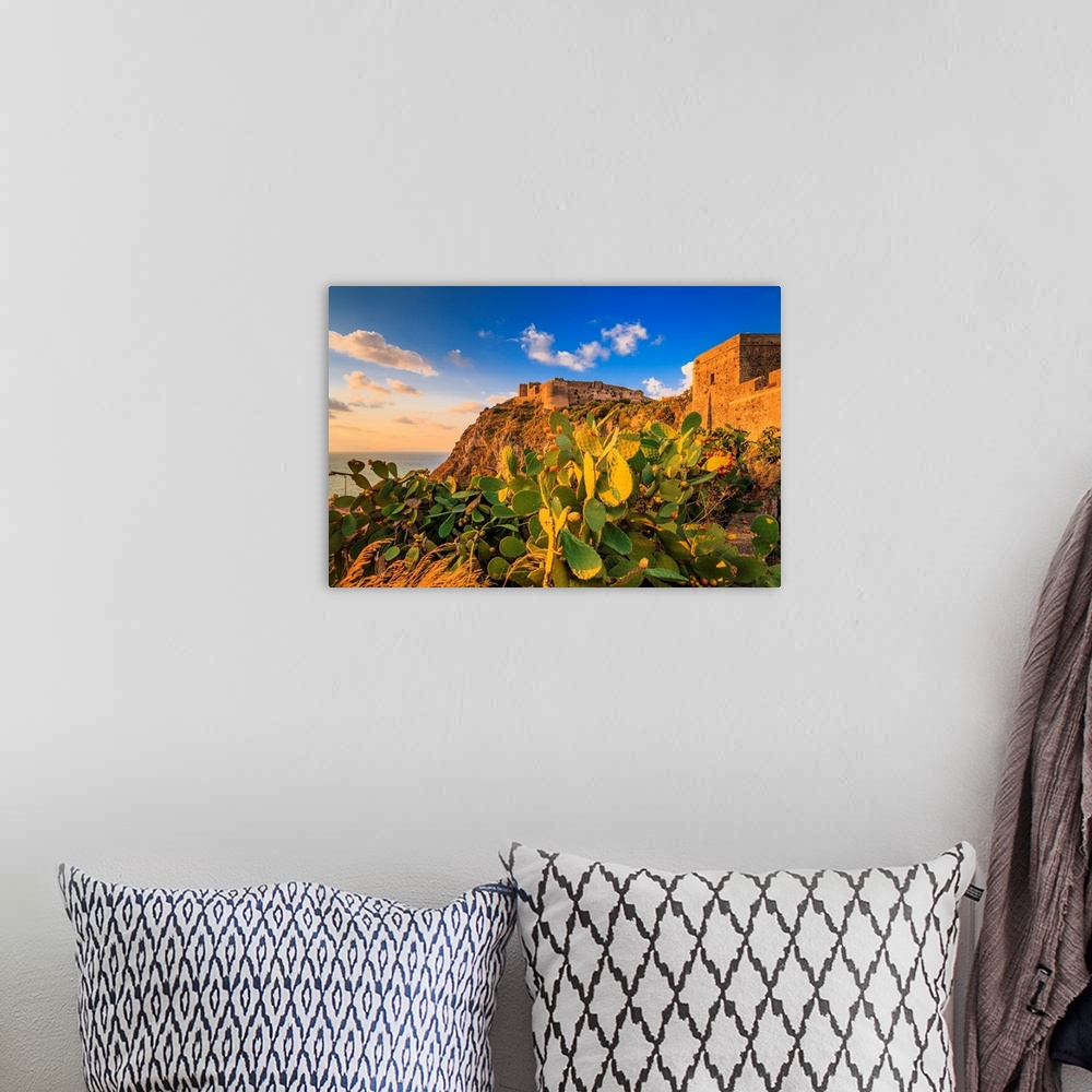 A bohemian room featuring Italy, Sicily, Messina district, Mediterranean sea, Milazzo, Castle at sunset.