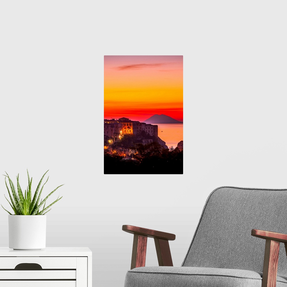 A modern room featuring Italy, Calabria, Mediterranean area, Vibo Valentia district, Tropea, Town at sunset with Strombol...