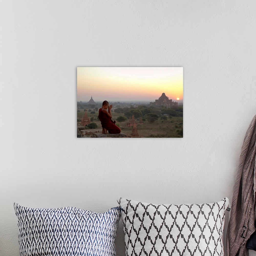 A bohemian room featuring Myanmar, Bagan, A novice Buddhist monk prays on a temple at sunrise