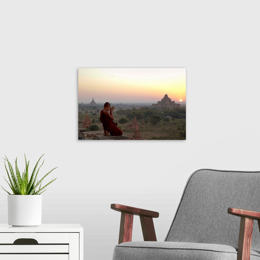 A modern room featuring Myanmar, Bagan, A novice Buddhist monk prays on a temple at sunrise