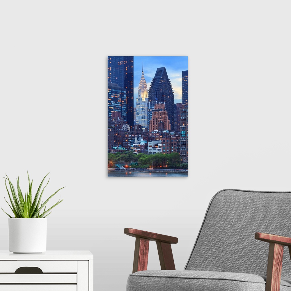 A modern room featuring USA, New York City, Manhattan, Midtown, Chrysler Building, View towards Manhattan at dusk from Ro...