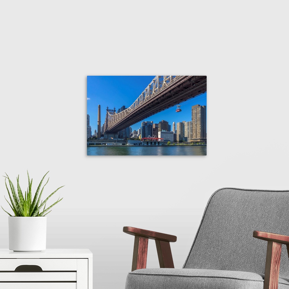 A modern room featuring New York, NYC, Manhattan, City skyline, Queensboro Bridge, and Roosevelt Island Tram viewed from ...