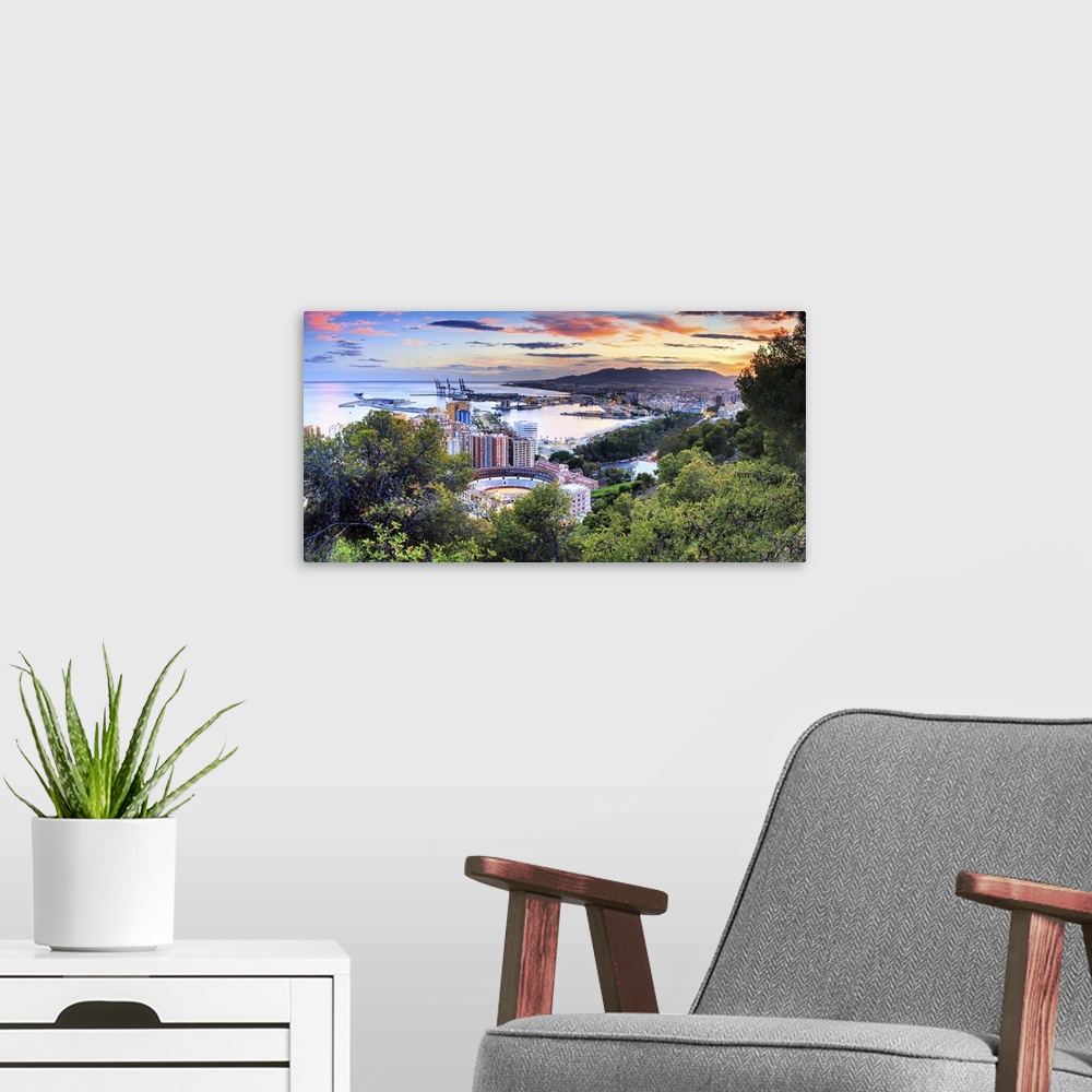 A modern room featuring Spain, Andalusia, Malaga district, Malaga, Cityscape with the famous bullring at sunset, view fro...