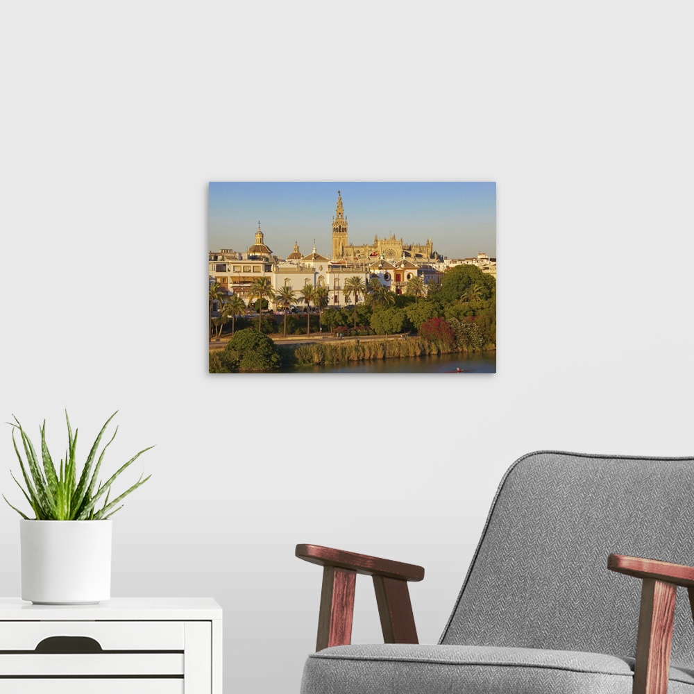 A modern room featuring Spain, Andalusia, Mediterranean area, Seville, Guadalquivir river with the Cathedral in background
