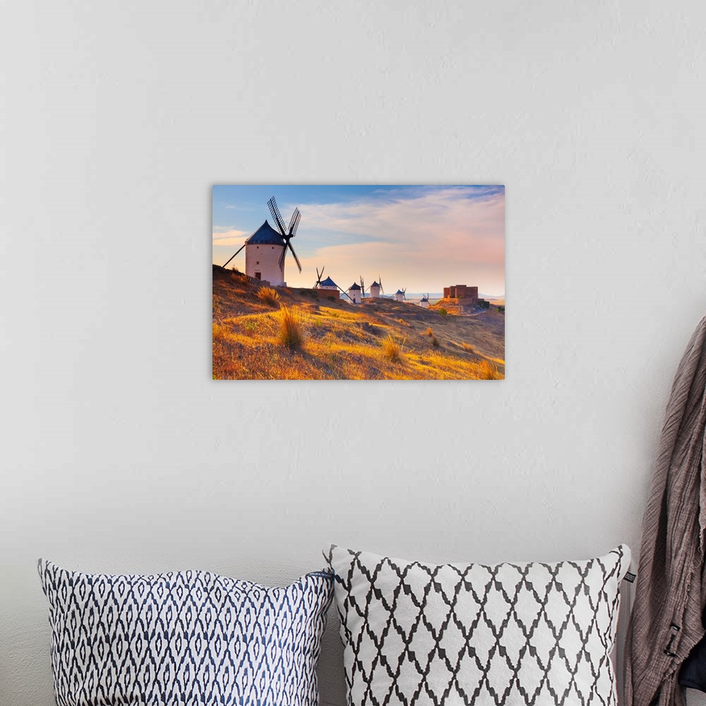 A bohemian room featuring Spain, Castilla-La Mancha, Consuegra, Windmills and the castle near the village, sunrise.