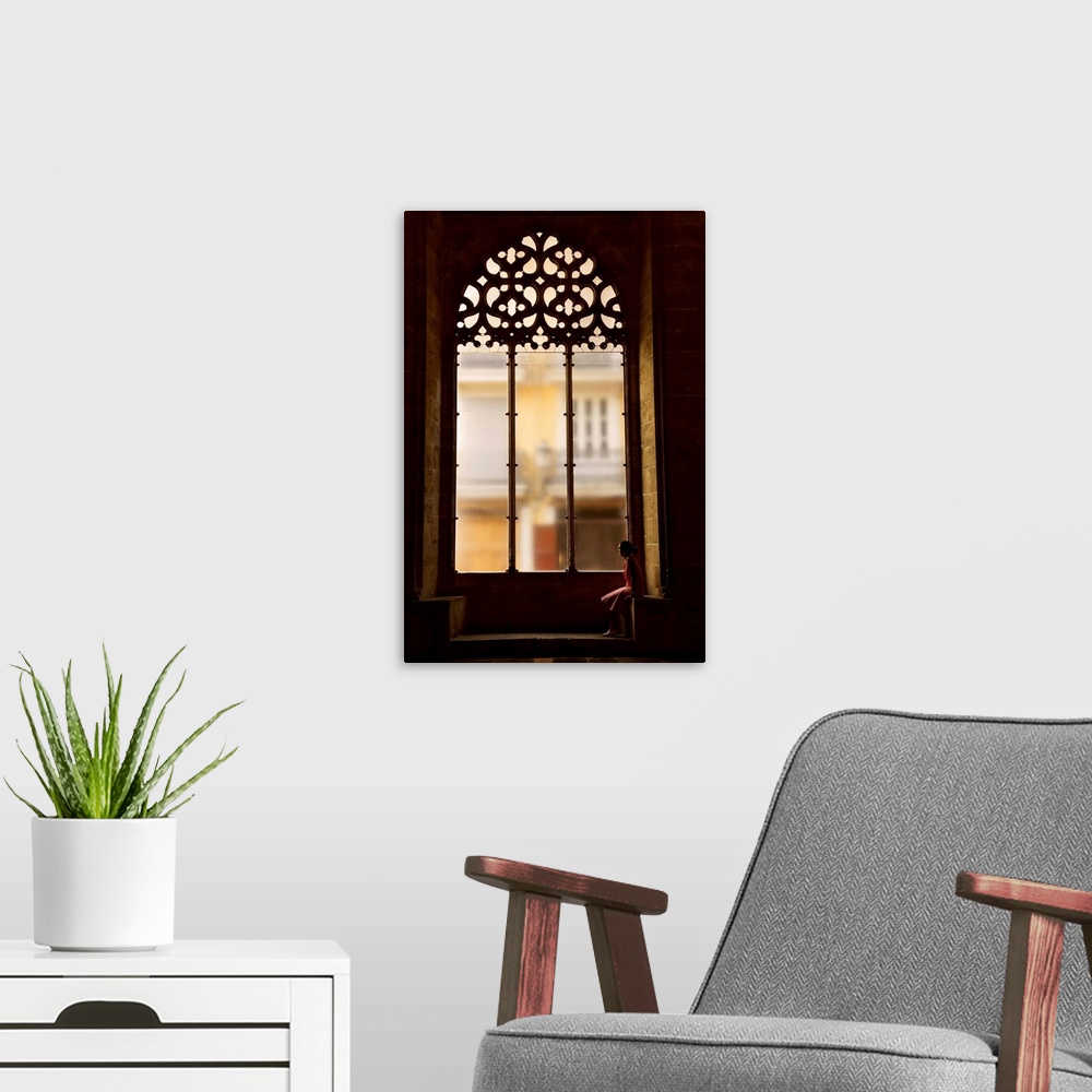 A modern room featuring Spain, Comunidad Valenciana, Valencia, Hall of Lonja de La Seda, Woman sitting by a window