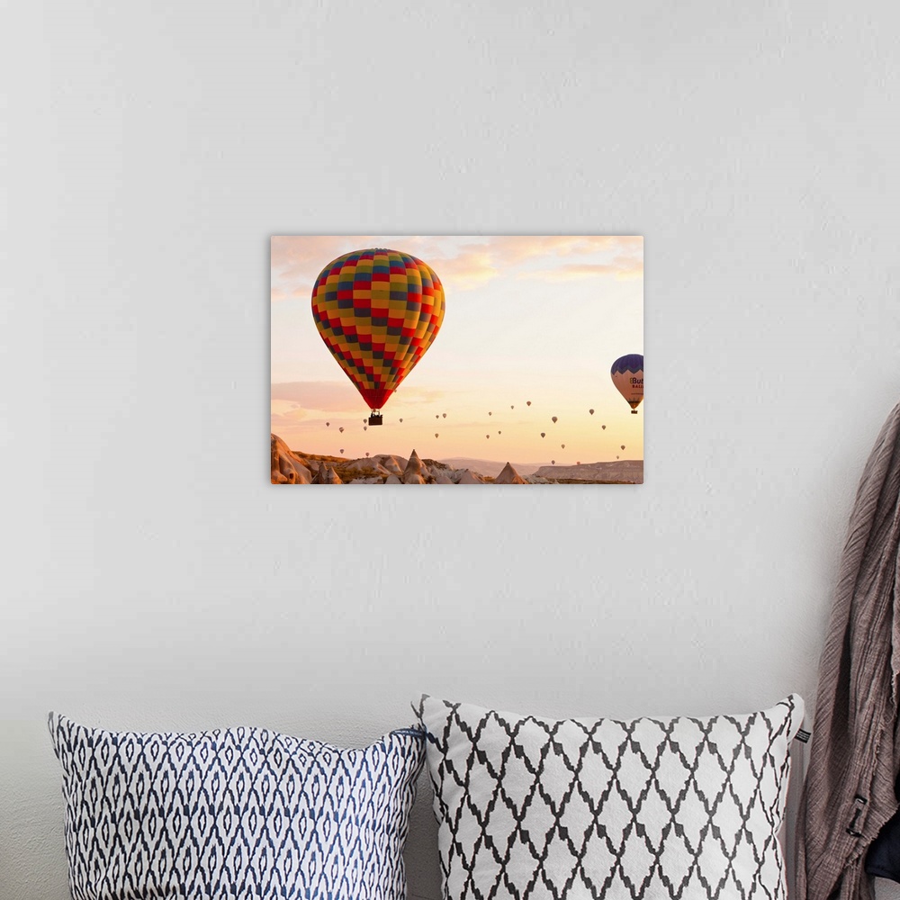 A bohemian room featuring Turkey, Central Anatolia, Cappadocia, Hot air balloons at sunset.