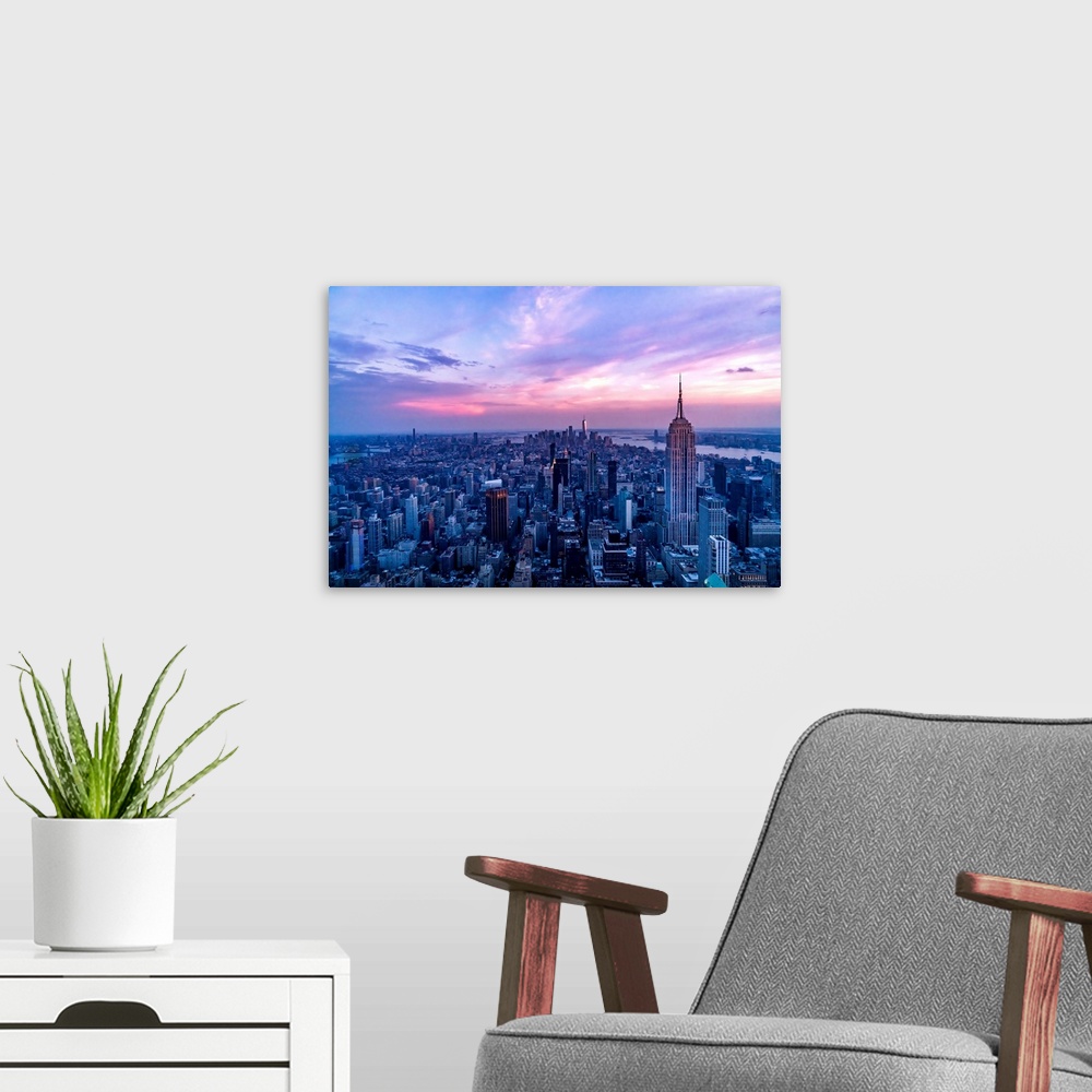 A modern room featuring USA, New York City, Manhattan, Empire State Building, dramatic pink sky and light over Manhattan.