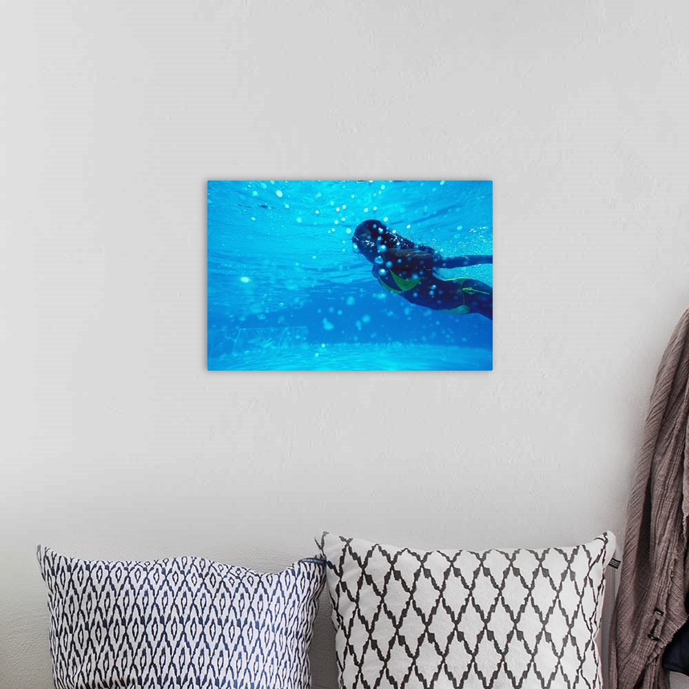 A bohemian room featuring Young woman swimming underwater, in pool