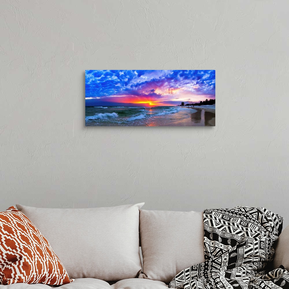 A bohemian room featuring An amazing beach sunset panorama with waves and blue clouds.