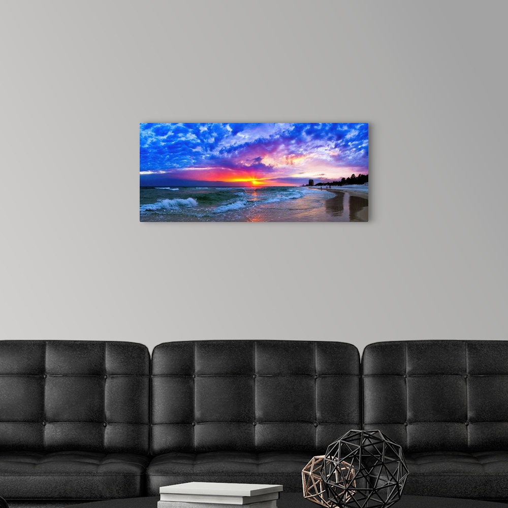 A modern room featuring An amazing beach sunset panorama with waves and blue clouds.
