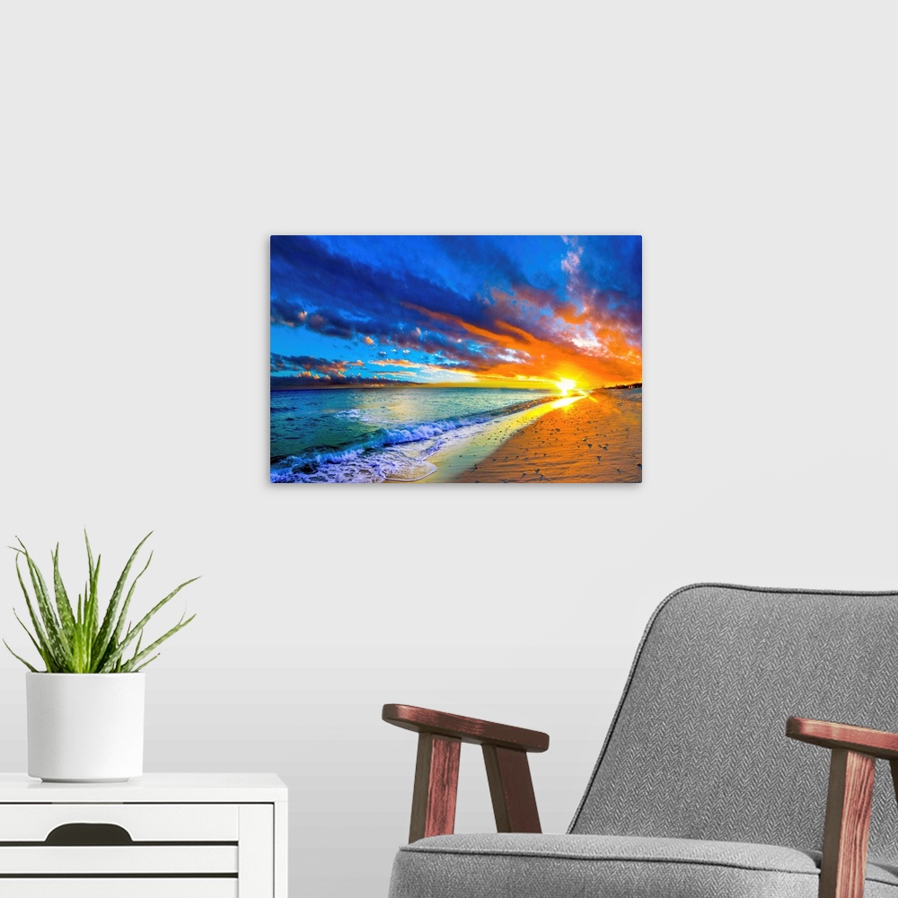A modern room featuring A blue ocean sunrise with white crested waves. A colorful seascape sunset with an orange sun.