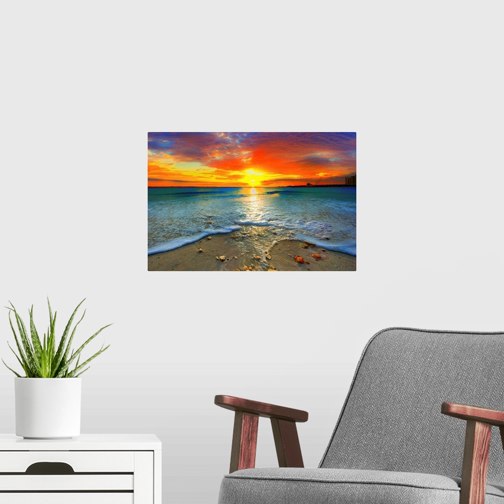 A modern room featuring A dark red ocean sunset at seashore. Gentle blue ocean waves roll over the shore.