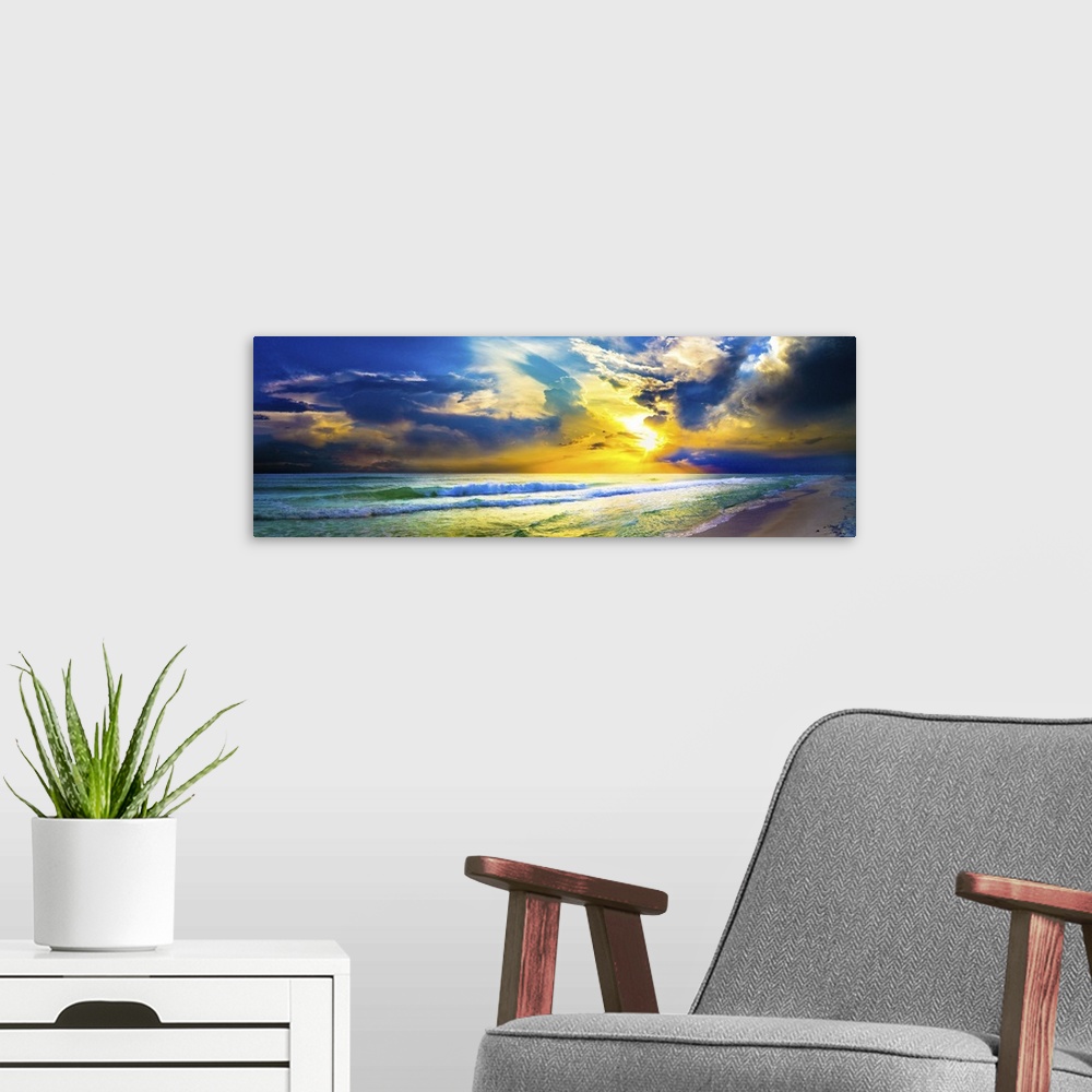 A modern room featuring A bright yellow sunset sky over waves as the hit the beach in this beautiful landscape. A beautif...
