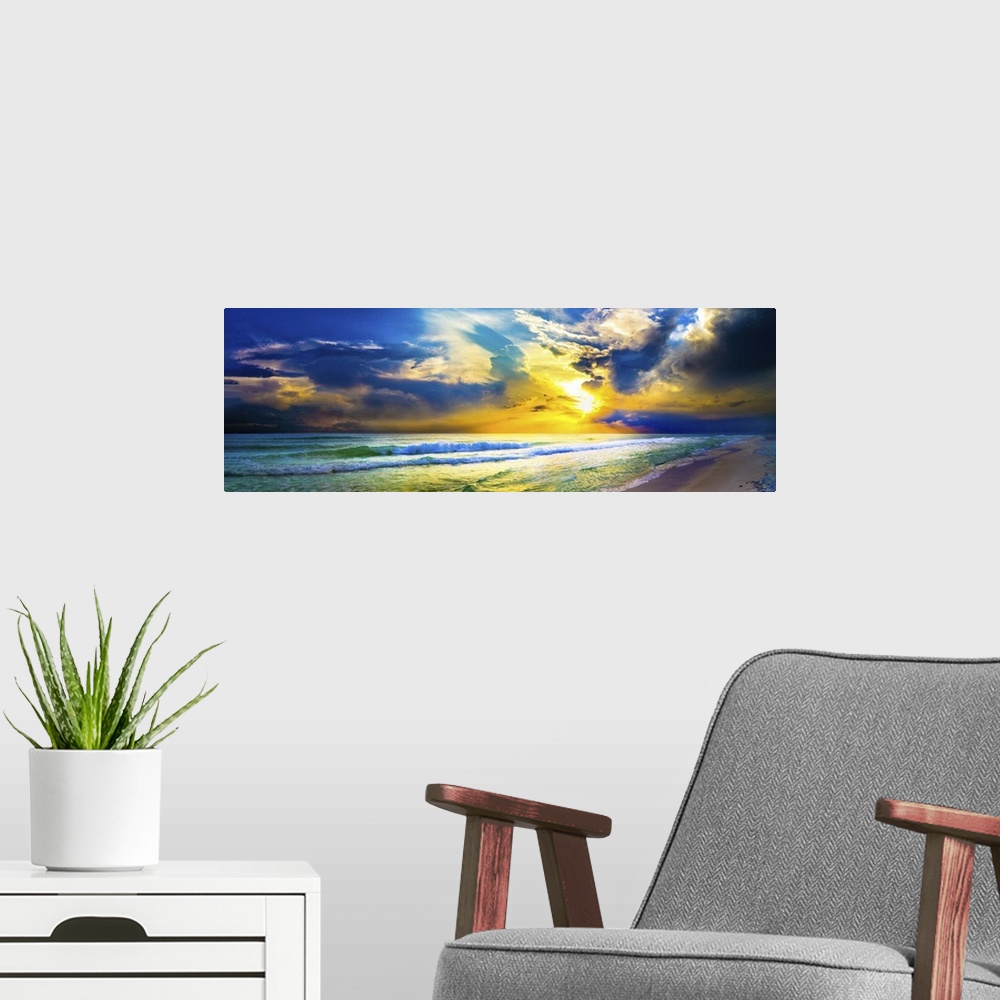 A modern room featuring A bright yellow sunset sky over waves as the hit the beach in this beautiful landscape. A beautif...
