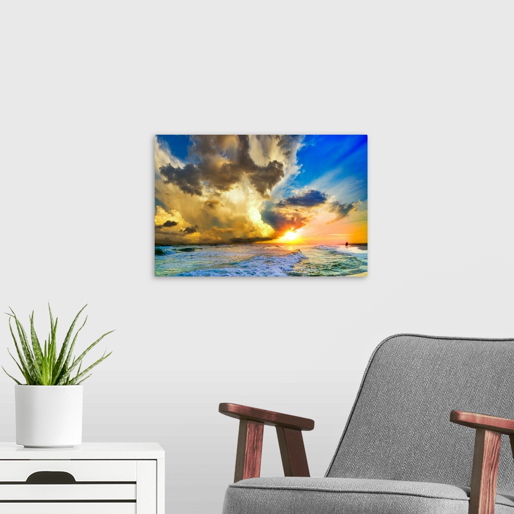 A modern room featuring Tall clouds before a blue sky and a sunset over a beautiful beach landscape.