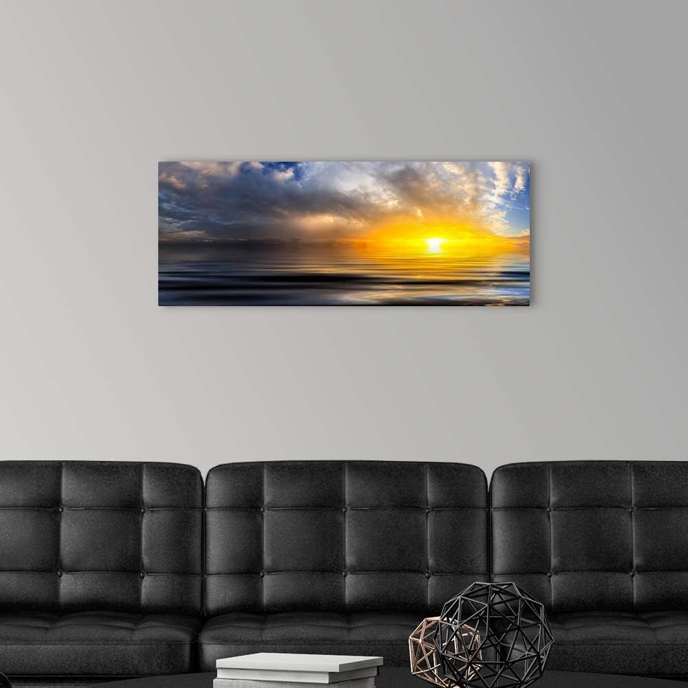 A modern room featuring A beautiful golden panoramic sunset reflected in the ocean waves at sunset with bright spiraling ...