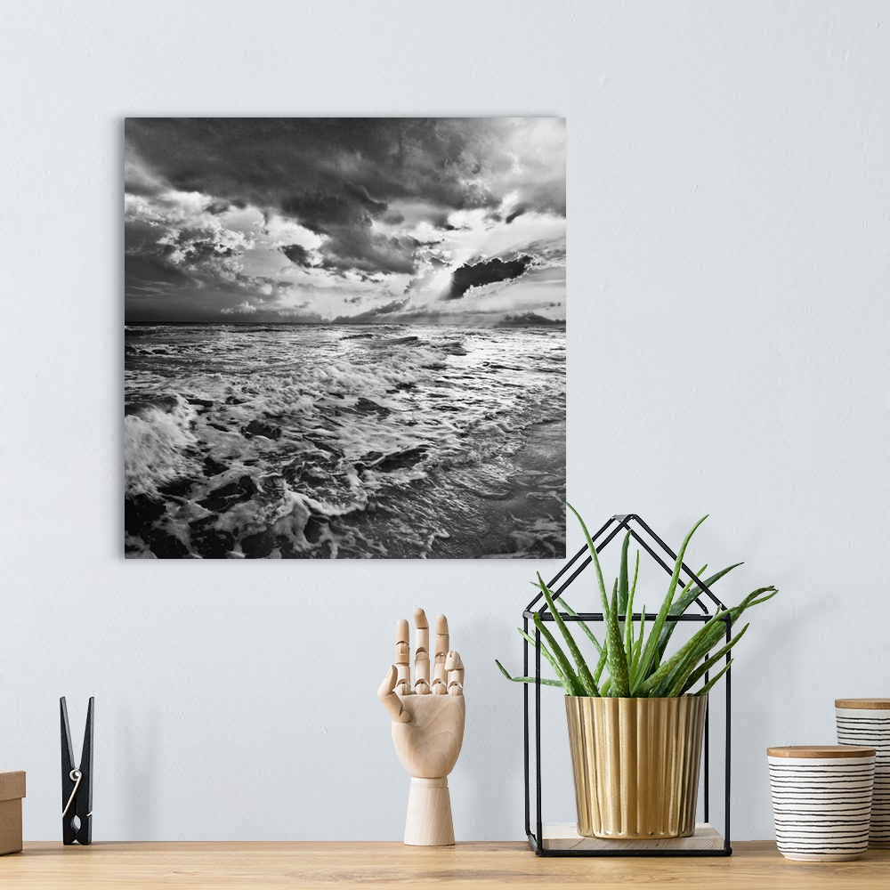 A bohemian room featuring A black and white image of the sea with crashing waves on the beach.