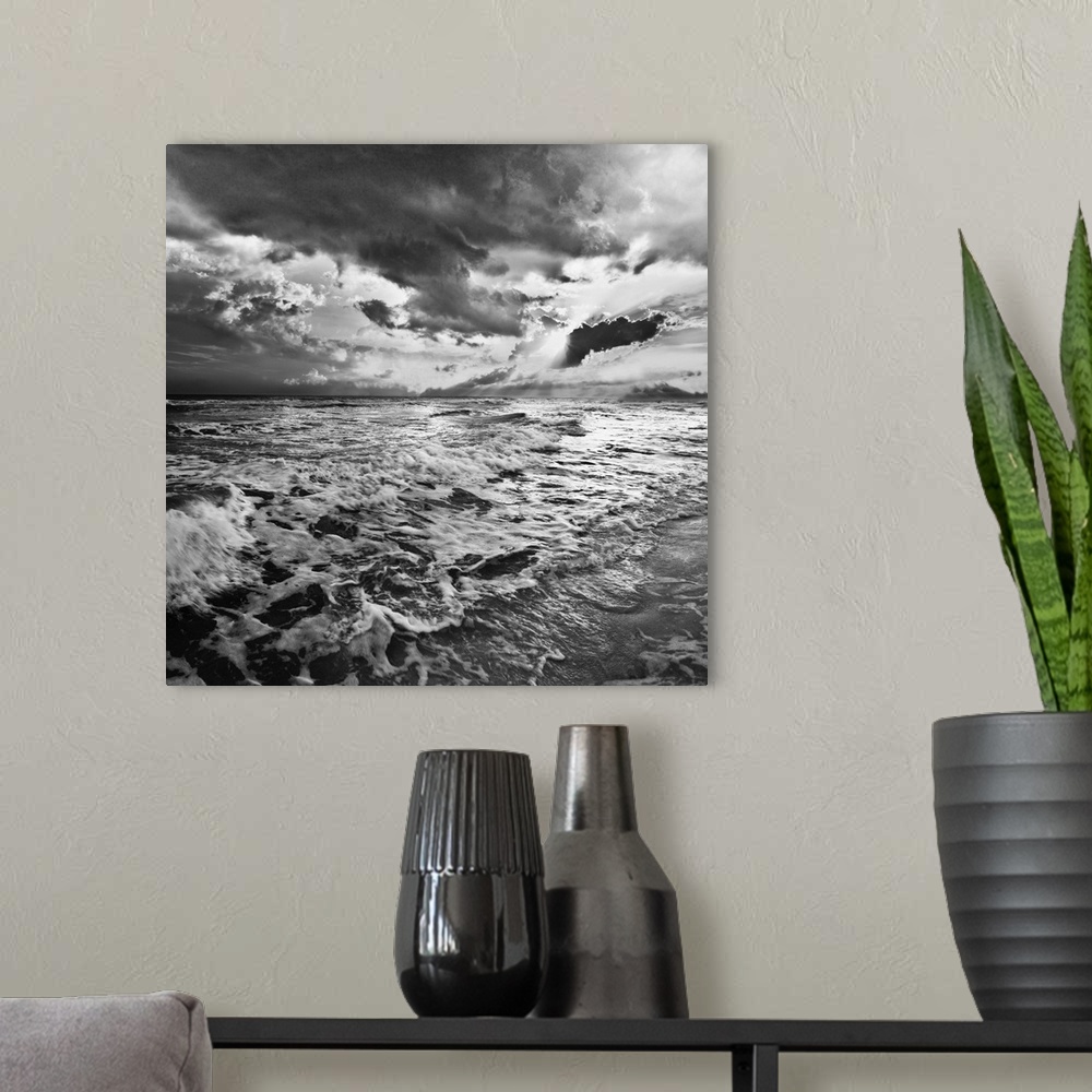A modern room featuring A black and white image of the sea with crashing waves on the beach.