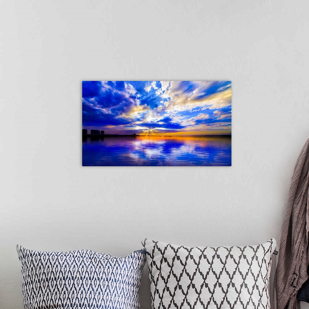 A bohemian room featuring The sunset reflected in this blue and white seascape during sunset.