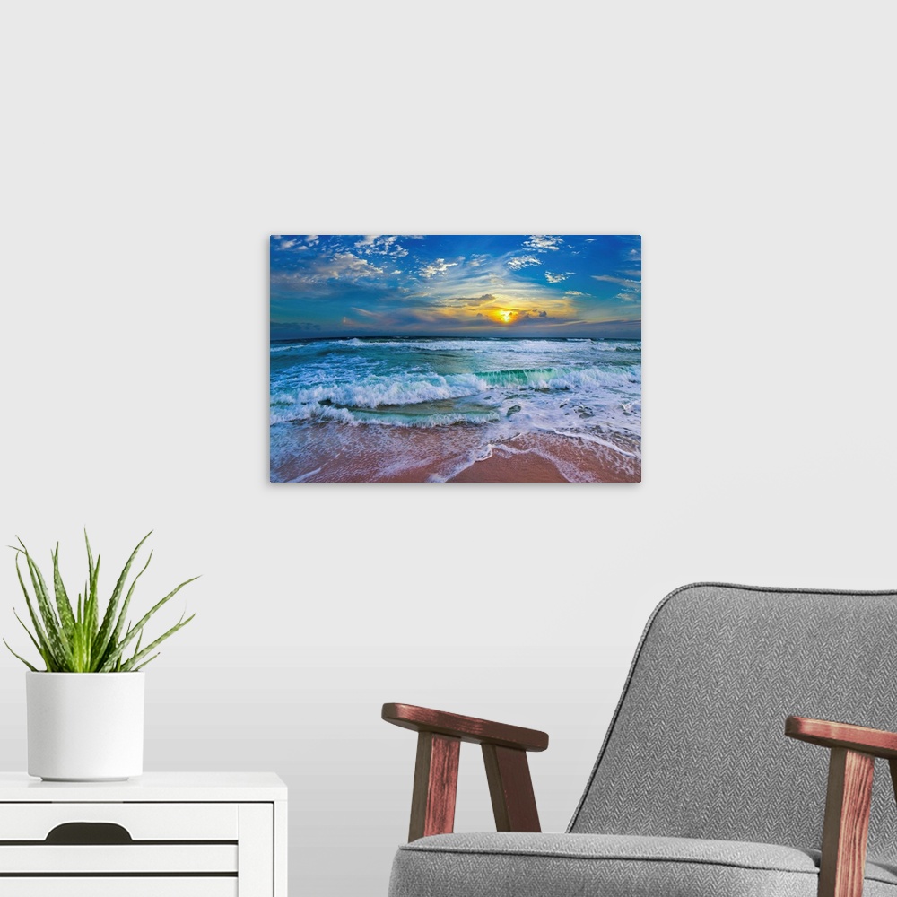 A modern room featuring A glimpse of a yellow sunset within a cold blue sunset. Blue waves hit a tropical sea shore.