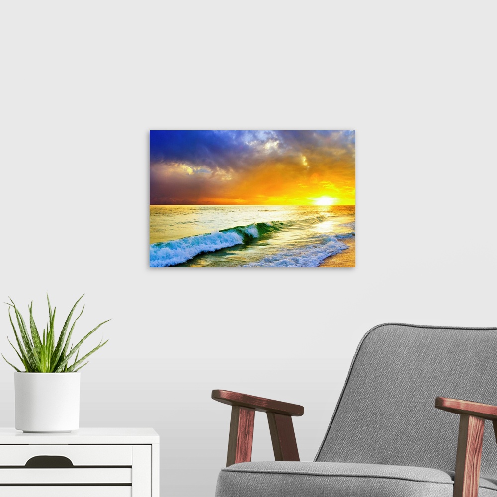 A modern room featuring Waves breaking from an emerald sea beneath an orange and blue ocean sunset with green sea surf.