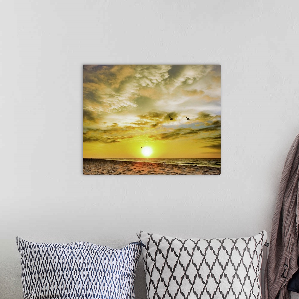 A bohemian room featuring A beautiful Destin Beach Sunrise with orange and white clouds.