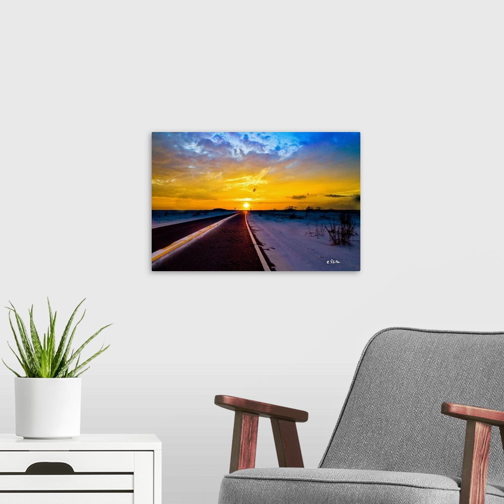 A modern room featuring A landscape driving into the sunset on the open road.