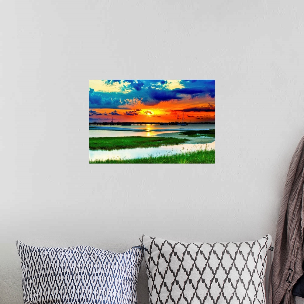 A bohemian room featuring Green grass panoramic. Red sunset over the lake and islands of green grass.
