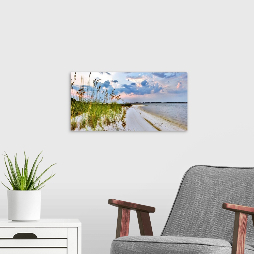 A modern room featuring A panoramic with blue and purple clouds over a grassy beach. Sea Oats can be seen reaching into t...