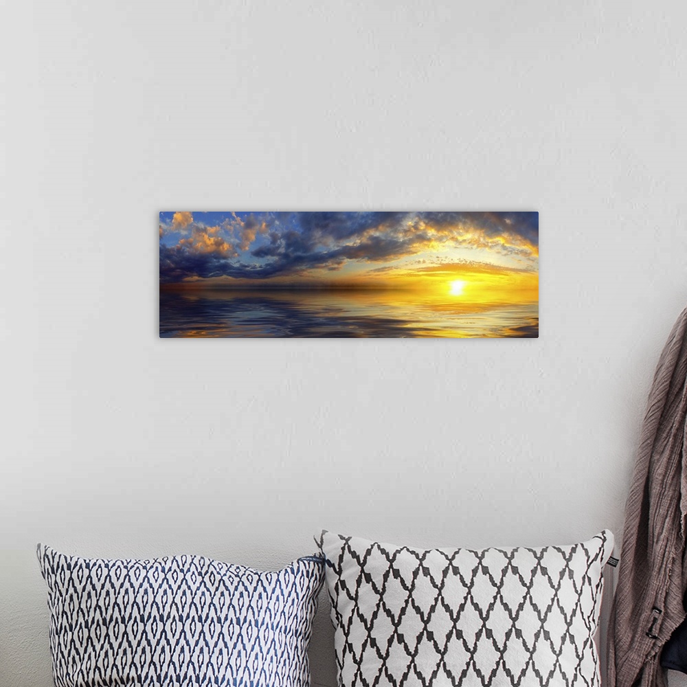 A bohemian room featuring A beautiful panoramic sunset with bright yellow clouds and a golden cloudscape reflected in the sea.