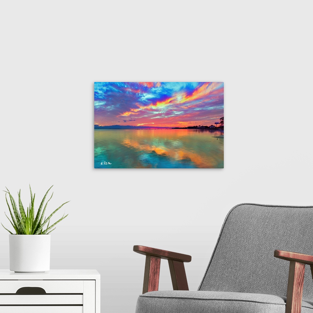 A modern room featuring Cloud streaks reflected in this pink sunset over the sea.