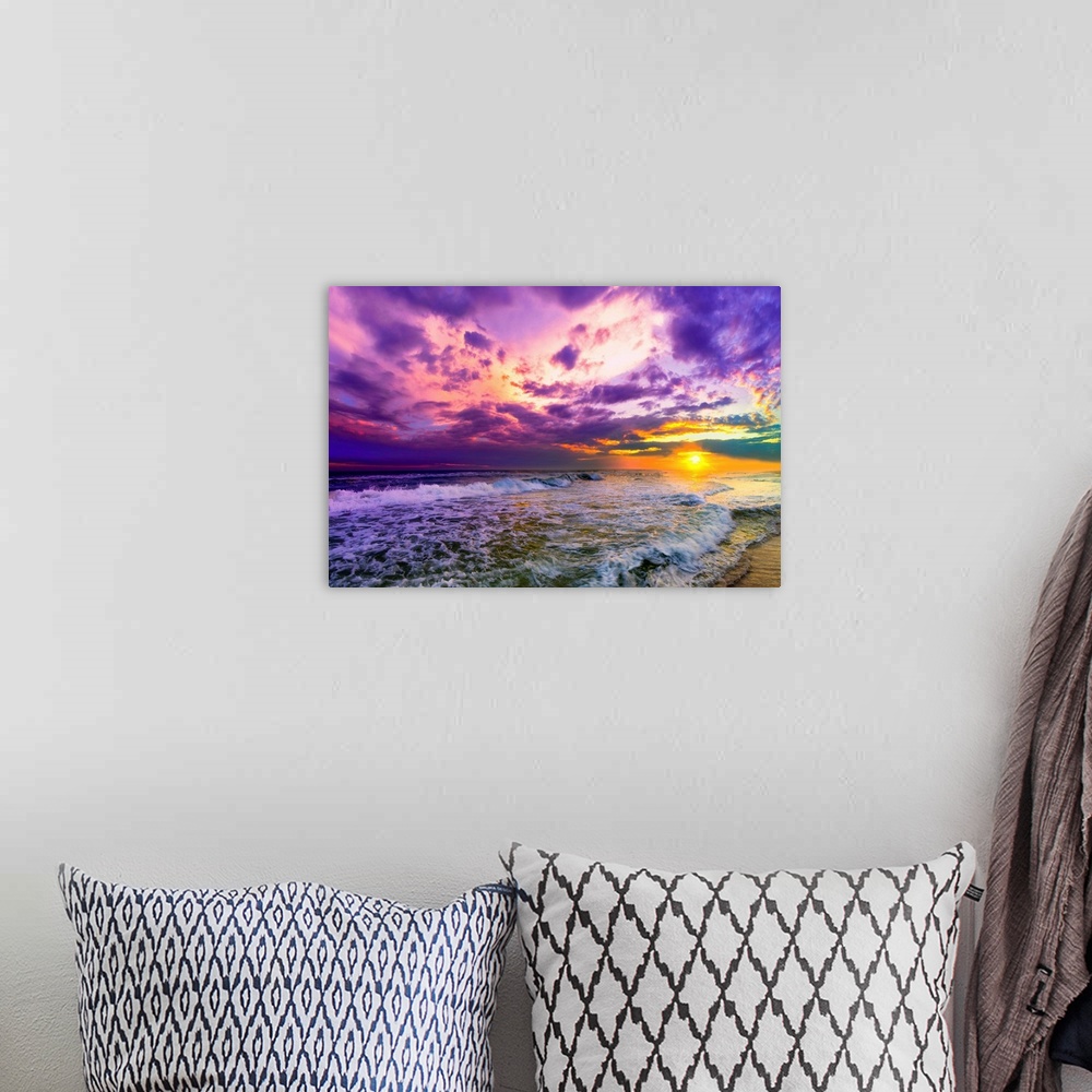 A bohemian room featuring A beach sunset with beautiful pink and purple clouds. The ocean is littered with foamy waves unde...