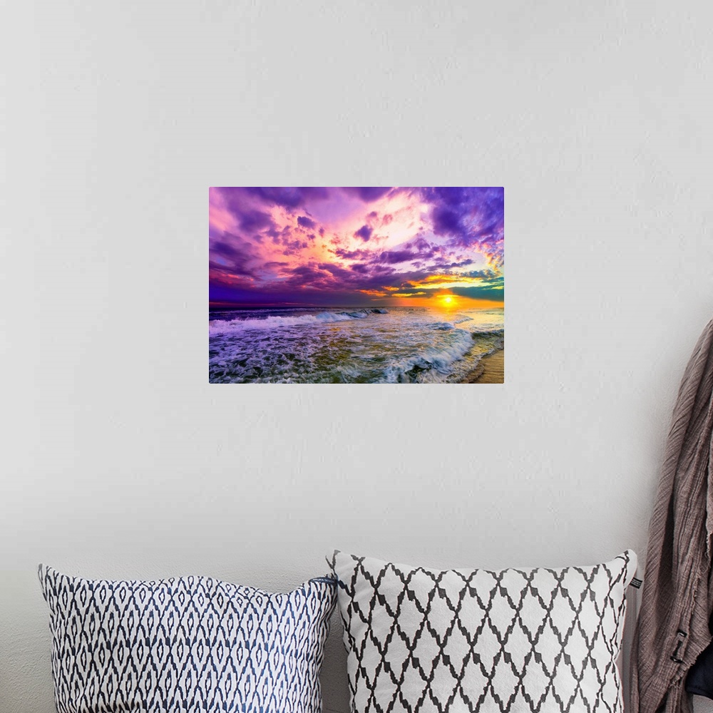A bohemian room featuring A beach sunset with beautiful pink and purple clouds. The ocean is littered with foamy waves unde...