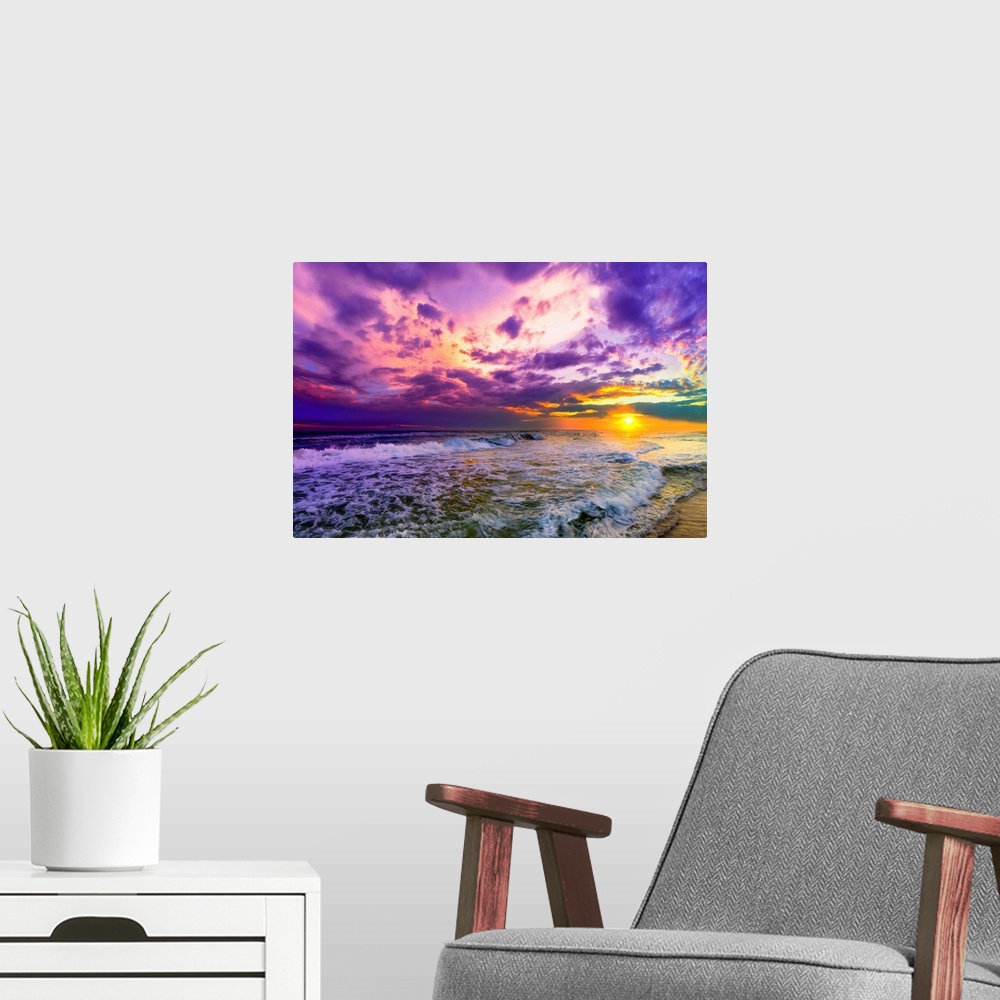 A modern room featuring A beach sunset with beautiful pink and purple clouds. The ocean is littered with foamy waves unde...