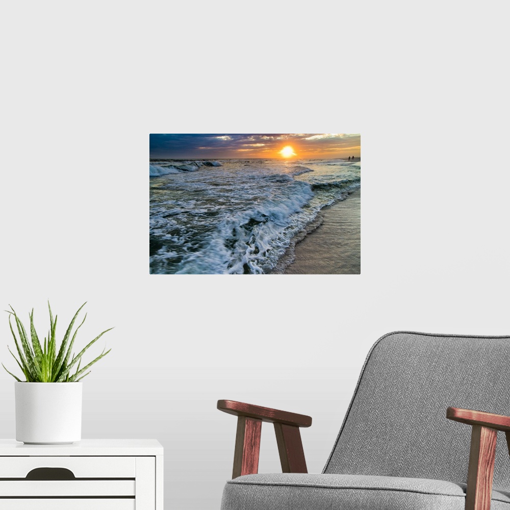 A modern room featuring A sunset with crashing waves on the shoreline.
