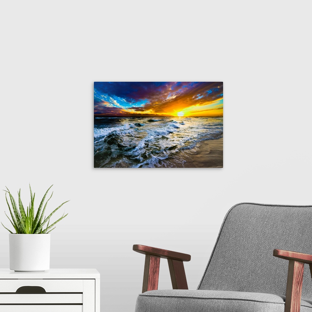 A modern room featuring A red and blue sunset on the beach with a turbulent ocean with waves. Strong dark to light contra...