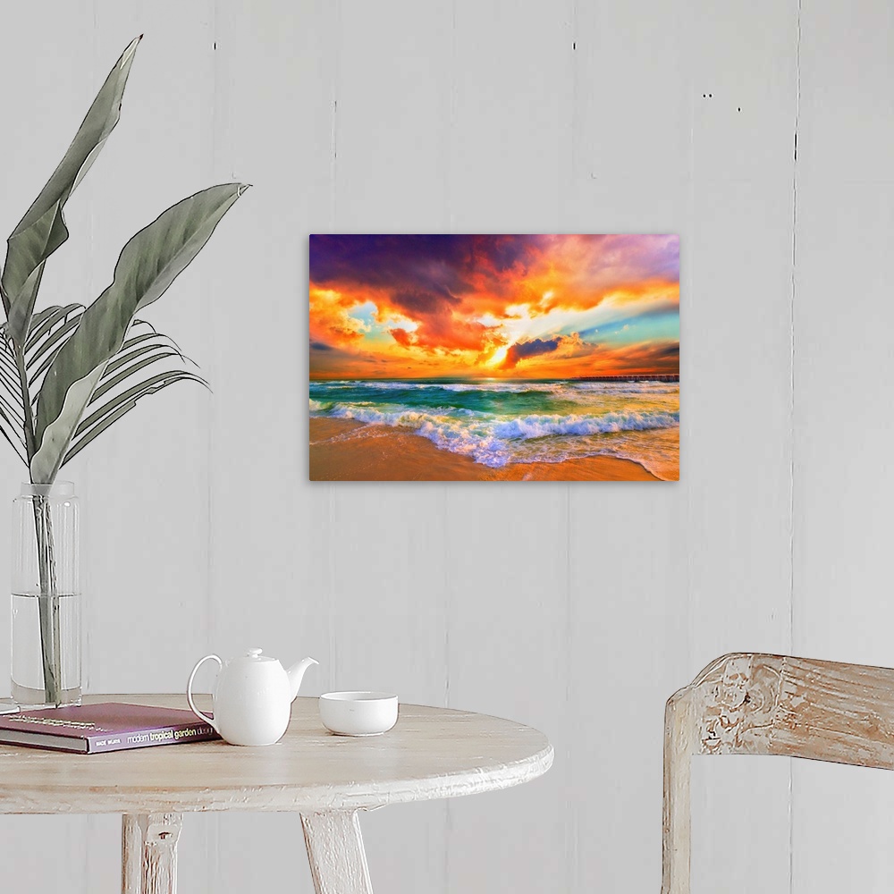 A farmhouse room featuring A red, orange and purple sunset on the beach. Beautiful ocean waves roll onto the sea shore.