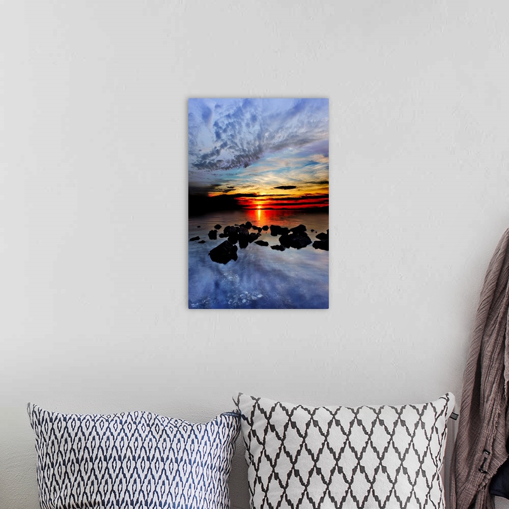 A bohemian room featuring Blue clouds reflected in the sea in the red sunset landscape.